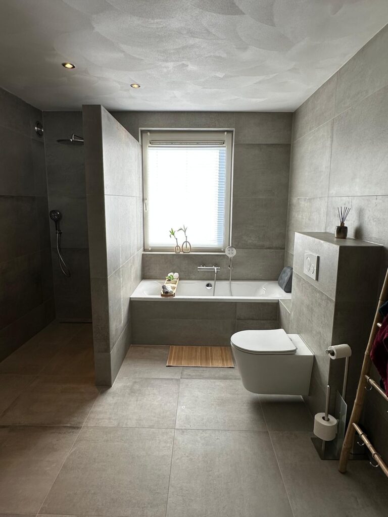 Grijze badkamer in betonlook met inloopdouche en bad - foto 2
