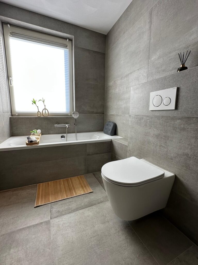 Grijze badkamer in betonlook met inloopdouche en bad - foto 3
