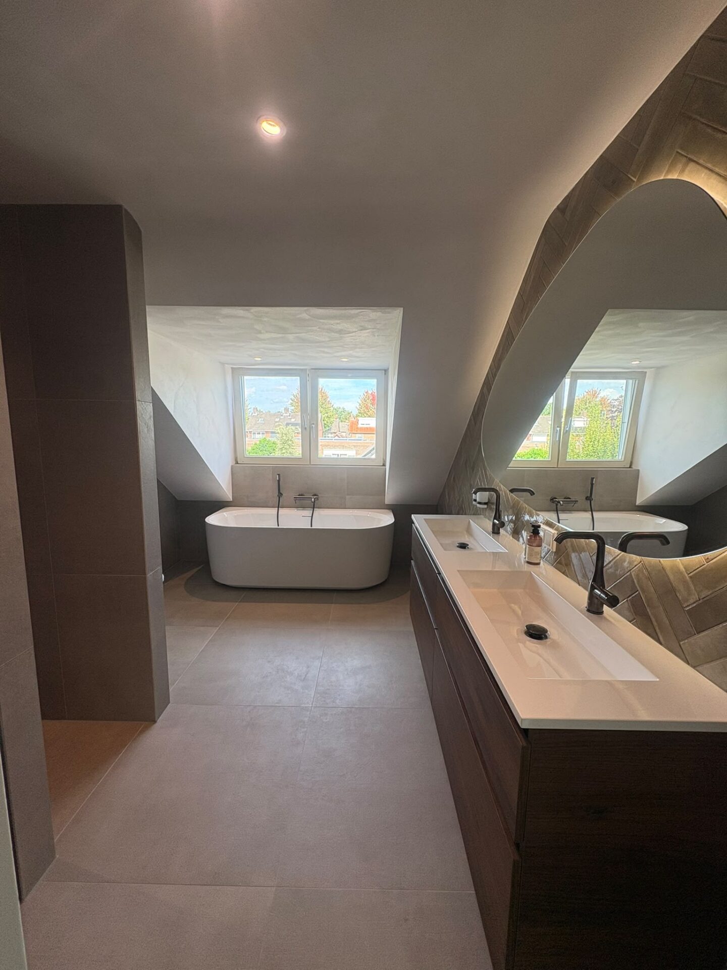 Zolderbadkamer met walnoot meubel en vrijstaand bad